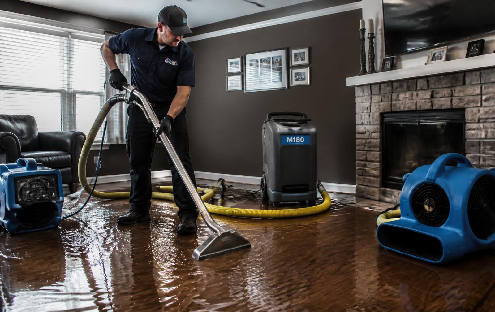 Restoration technician extracting water from a flooded San Antonio home